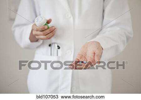 Doctor holding handful of pills View Large Photo Image Stock Image - Doctor holding handful of pills. Fotosearch