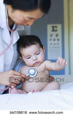 Doctor listening to baby's heartbeat in office View Large Photo Image Stock Photo - Doctor listening to baby's heartbeat in office. Fotosearch
