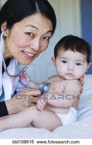 Doctor listening to baby's heartbeat in office View Large Photo Image Stock Photograph - Doctor listening to baby's heartbeat in office. Fotosearch