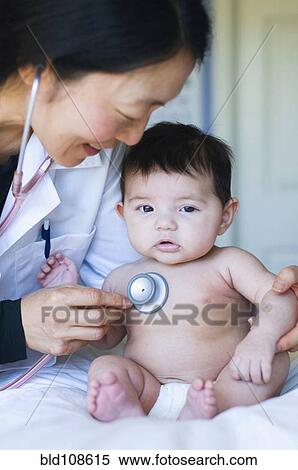 Stock Photography - Doctor listening to baby's heartbeat in office. Fotosearch