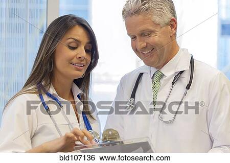 Stock Photograph - Doctors reading from clipboard. Fotosearch