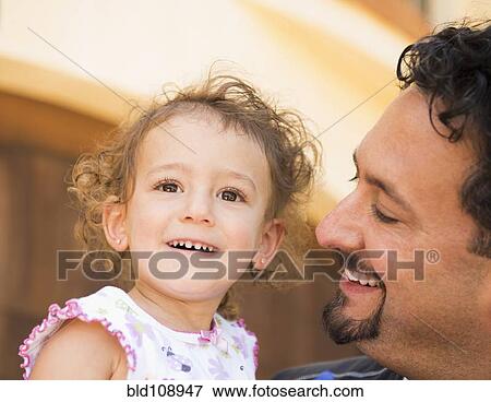 Stock Photo - Father smiling at daughter. Fotosearch
