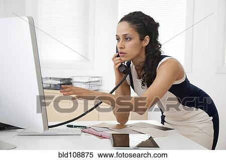 Stock Photography - Hispanic businesswoman talking on phone. Fotosearch