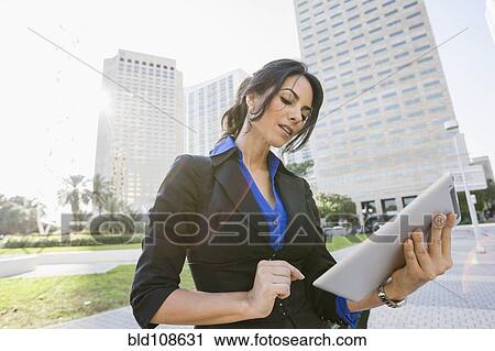 Stock Image - Hispanic businesswoman using digital tablet. Fotosearch