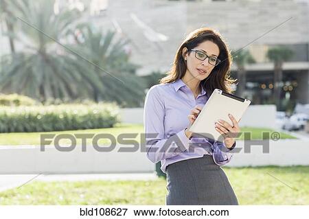 Hispanic businesswoman using digital tablet View Large Photo Image Stock Photo - Hispanic businesswoman using digital tablet. Fotosearch