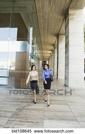 Stock Photography - Hispanic businesswomen walking together. Fotosearch
