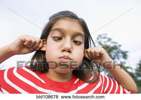 Stock Photo - Hispanic girl making face outdoors. Fotosearch