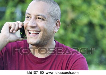 Stock Image - Hispanic man talking on cell phone. Fotosearch
