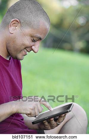 Hispanic man using tablet computer View Large Photo Image Stock Image - Hispanic man using tablet computer. Fotosearch