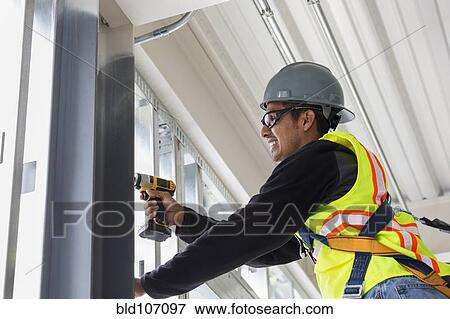 Stock Photo - Hispanic man working at construction site. Fotosearch