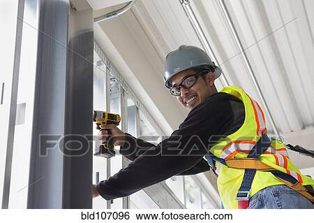 Hispanic man working at construction site View Large Photo Image Stock Photograph - Hispanic man working at construction site. Fotosearch