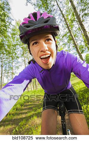 Stock Photography - Hispanic teenager riding bicycle in woods. Fotosearch