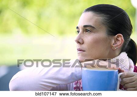 Stock Photo - Hispanic woman drinking coffee outdoors. Fotosearch