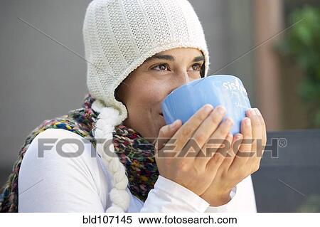 Stock Photography - Hispanic woman drinking coffee outdoors. Fotosearch