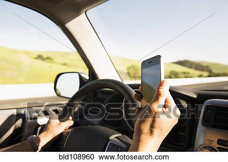 Hispanic woman driving and using cell phone View Large Photo Image Stock Image - Hispanic woman driving and using cell phone. Fotosearch