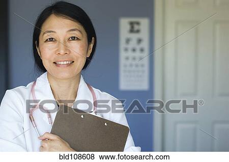 Japanese doctor standing in office View Large Photo Image Stock Photo - Japanese doctor standing in office. Fotosearch