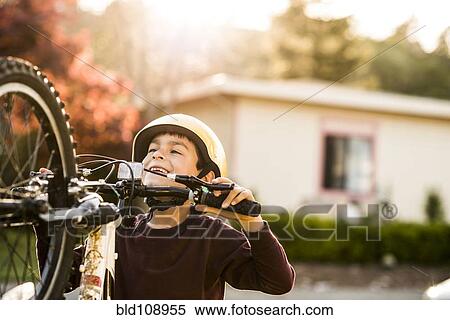 Mixed race boy playing with mountain bike View Large Photo Image Stock Photography - Mixed race boy playing with mountain bike. Fotosearch