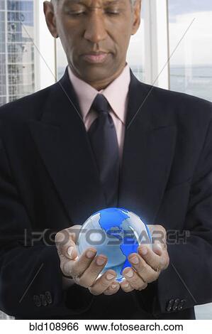 Mixed race businessman holding globe View Large Photo Image Stock Photograph - Mixed race businessman holding globe. Fotosearch