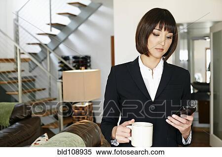 Stock Photography - Mixed race businesswoman having coffee. Fotosearch