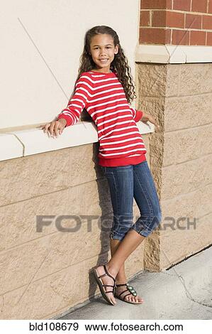 Mixed race girl leaning against brick wall View Large Photo Image Stock Photo - Mixed race girl leaning against brick wall. Fotosearch