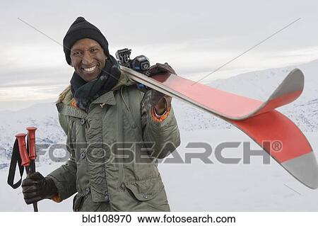 Mixed race man carrying skis on snowy slope View Large Photo Image Stock Image - Mixed race man carrying skis on snowy slope. Fotosearch