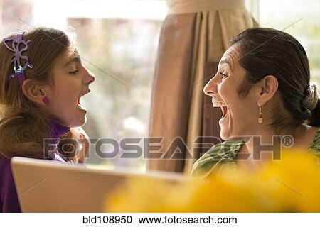 Stock Image - Mother and daughter talking at computer. Fotosearch