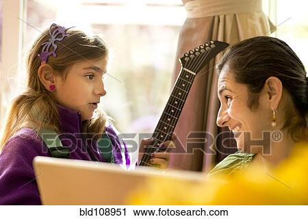 Stock Image - Mother and daughter talking at computer. Fotosearch