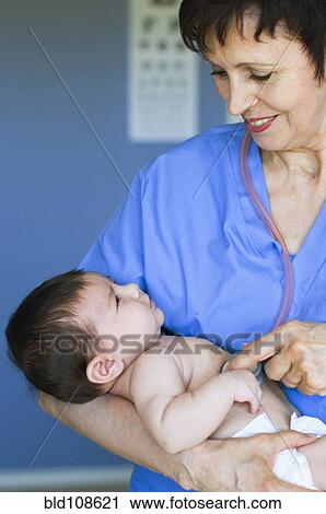 Nurse holding baby in doctor's office View Large Photo Image Stock Image - Nurse holding baby in doctor's office. Fotosearch