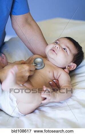 Stock Photo - Nurse listening to baby's heartbeat in office. Fotosearch