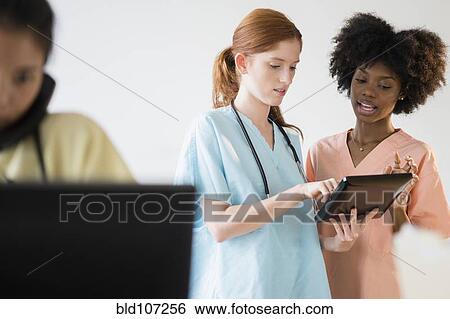 Nurses using tablet computer in hospital View Large Photo Image Stock Photograph - Nurses using tablet computer in hospital. Fotosearch