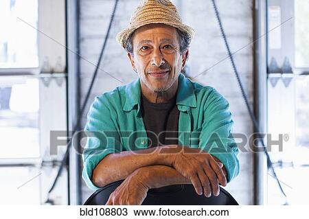 Stock Image - Older Caucasian man sitting in chair. Fotosearch