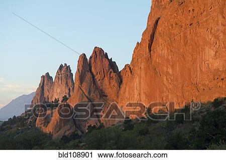 Stock Image - Red cliffs rising in rural landscape. Fotosearch
