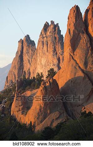 Stock Image - Red cliffs rising in rural landscape. Fotosearch