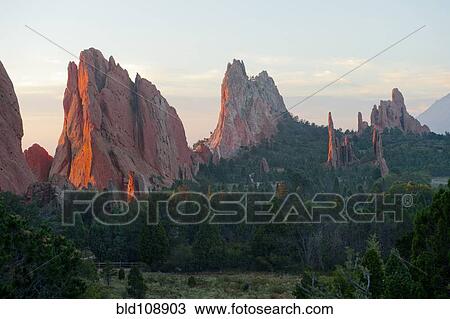 Stock Image - Red cliffs rising in rural landscape. Fotosearch