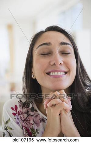 Stock Photography - Smiling Caucasian woman with hands clasped. Fotosearch