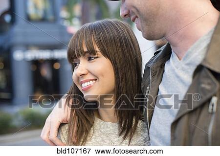 Smiling couple walking on city street View Large Photo Image Stock Photo - Smiling couple walking on city street. Fotosearch