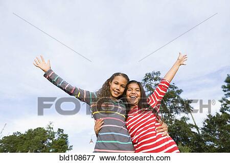Smiling girls hugging outdoors View Large Photo Image Stock Photo - Smiling girls hugging outdoors. Fotosearch