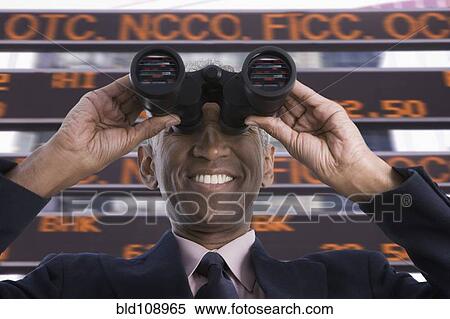 Stock Photography - Smiling mixed race businessman using binoculars. Fotosearch