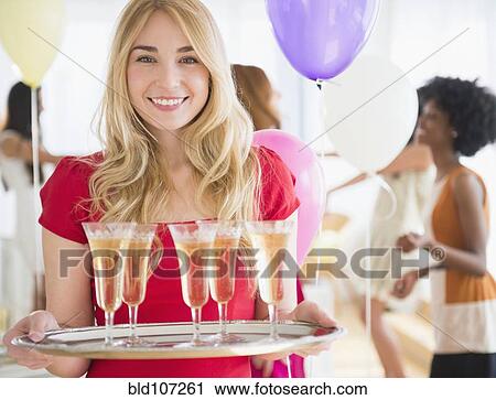 Smiling woman carrying tray of champagne View Large Photo Image Stock Image - Smiling woman carrying tray of champagne. Fotosearch