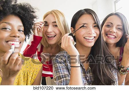 Stock Image - Smiling women applying make up. Fotosearch