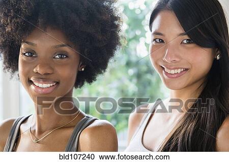 Stock Image - Smiling women standing together. Fotosearch