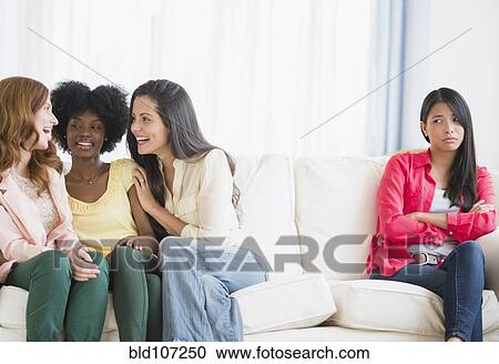 Stock Image - Woman excluded from conversation on sofa. Fotosearch