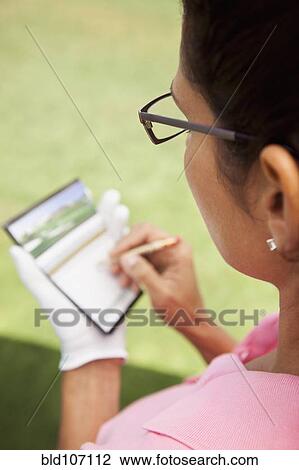 Woman keeping score during golf game View Large Photo Image Stock Image - Woman keeping score during golf game. Fotosearch