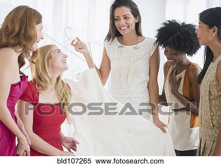 Stock Photography - Woman showing off new dress to friends. Fotosearch