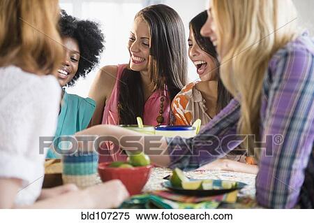 Women eating together at table View Large Photo Image Stock Photography - Women eating together at table. Fotosearch