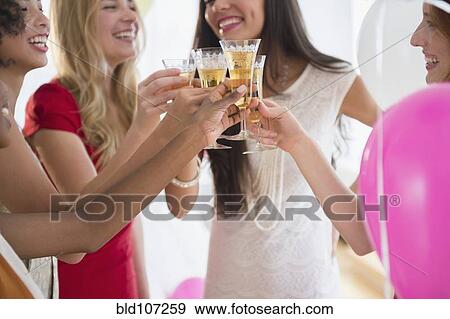Women toasting each other with champagne at party View Large Photo Image Stock Photo - Women toasting each other with champagne at party. Fotosearch
