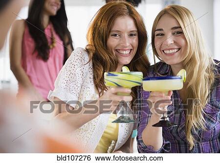 Women toasting each other with margaritas View Large Photo Image Stock Photograph - Women toasting each other with margaritas. Fotosearch