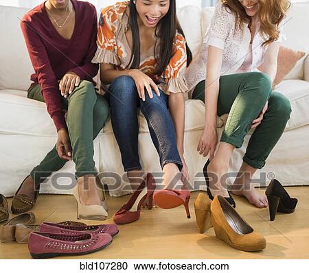 Women trying on shoes together View Large Photo Image Stock Image - Women trying on shoes together. Fotosearch