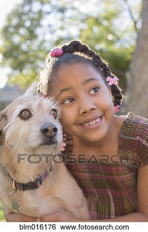 Stock Photograph - African American girl hugging dog. Fotosearch