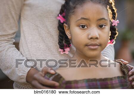 Stock Image - African American mother and daughter standing together. Fotosearch